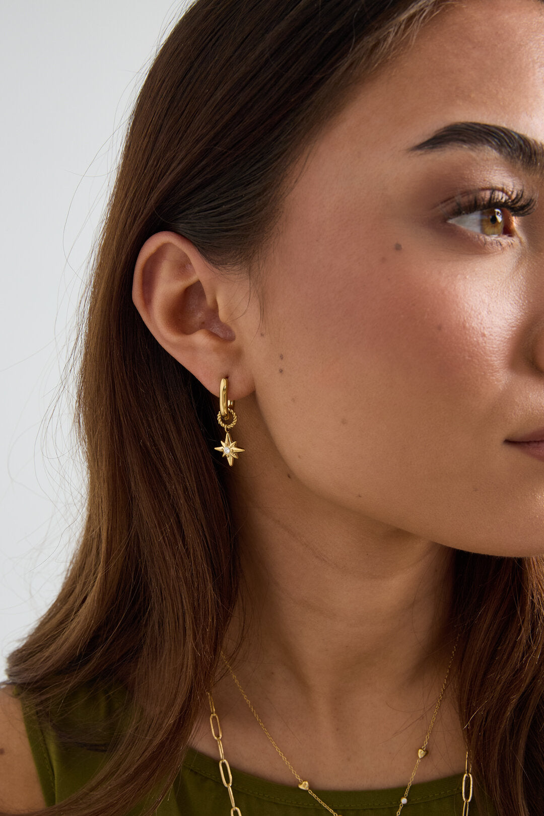 Boucles d'oreilles avec une étoile filante sur une petite bague