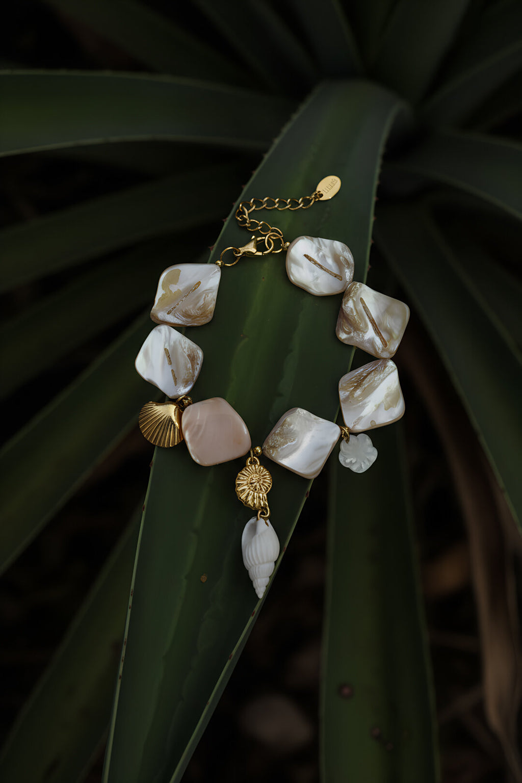 Bracelet beige orné de coquillages et de breloques marines