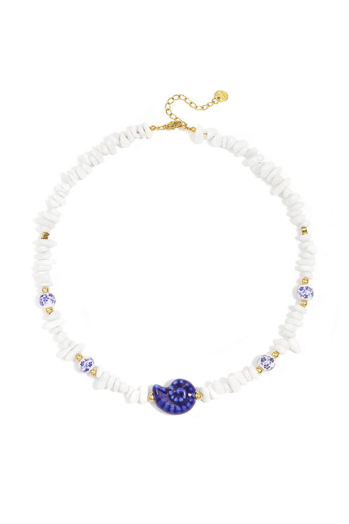 Collier composé de perles de pierre, de perles blanches ornées de fleurs bleues et d'un coquillage décoratif.