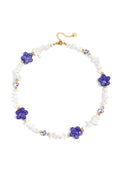 Collier composé de perles de pierre, de perles blanches ornées de fleurs bleues et de fleurs décoratives.