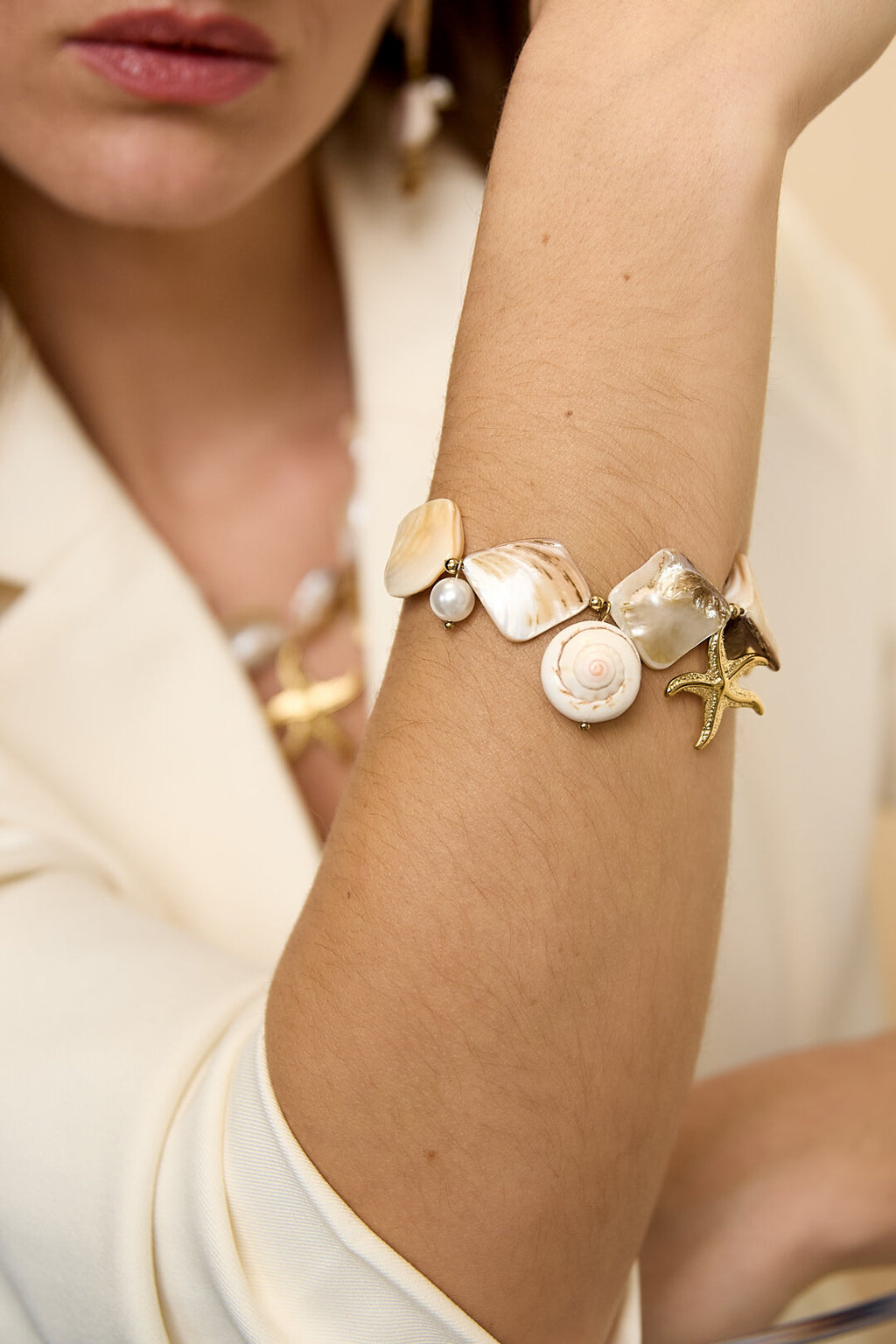 Bracelet orné de coquillages, de breloques marines et de perles dorées
