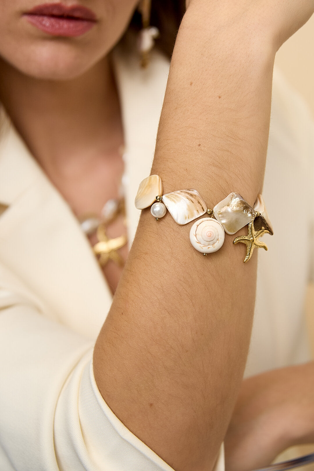 Bracelet orné de coquillages, de breloques marines et de perles dorées