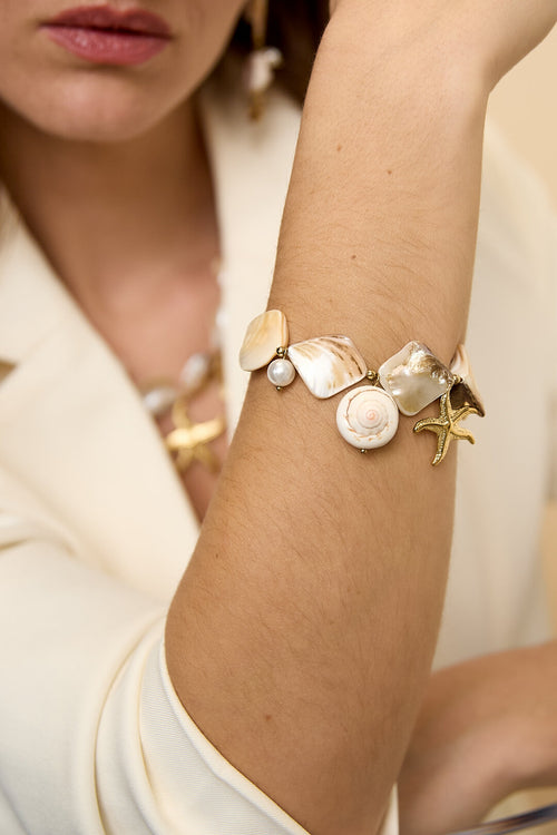 Bracelet orné de coquillages, de breloques marines et de perles dorées