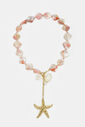 Collier orné de perles de coquillage, de breloques et d'une étoile de mer suspendue.