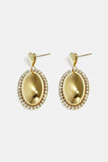 Boucles d'oreilles imposantes avec un pendentif ovale entouré de pierres